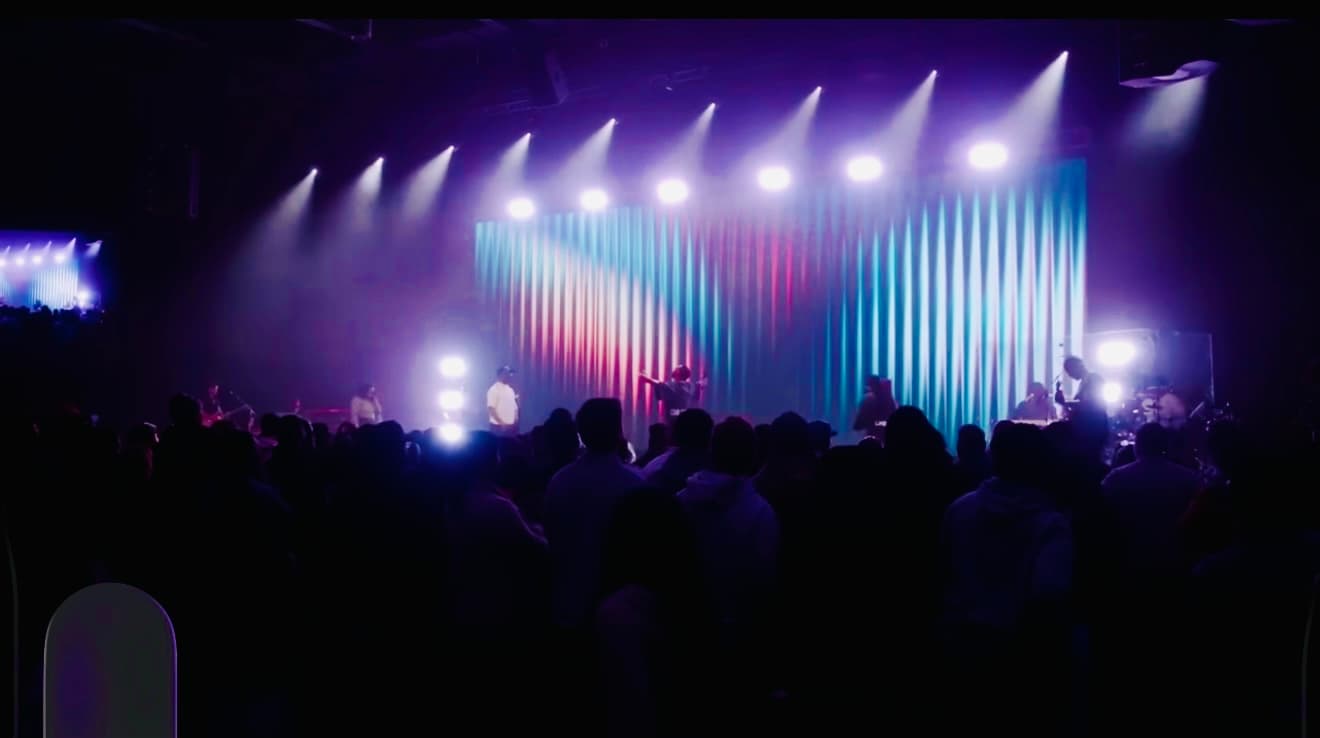 A lit stage and a full room at a live show